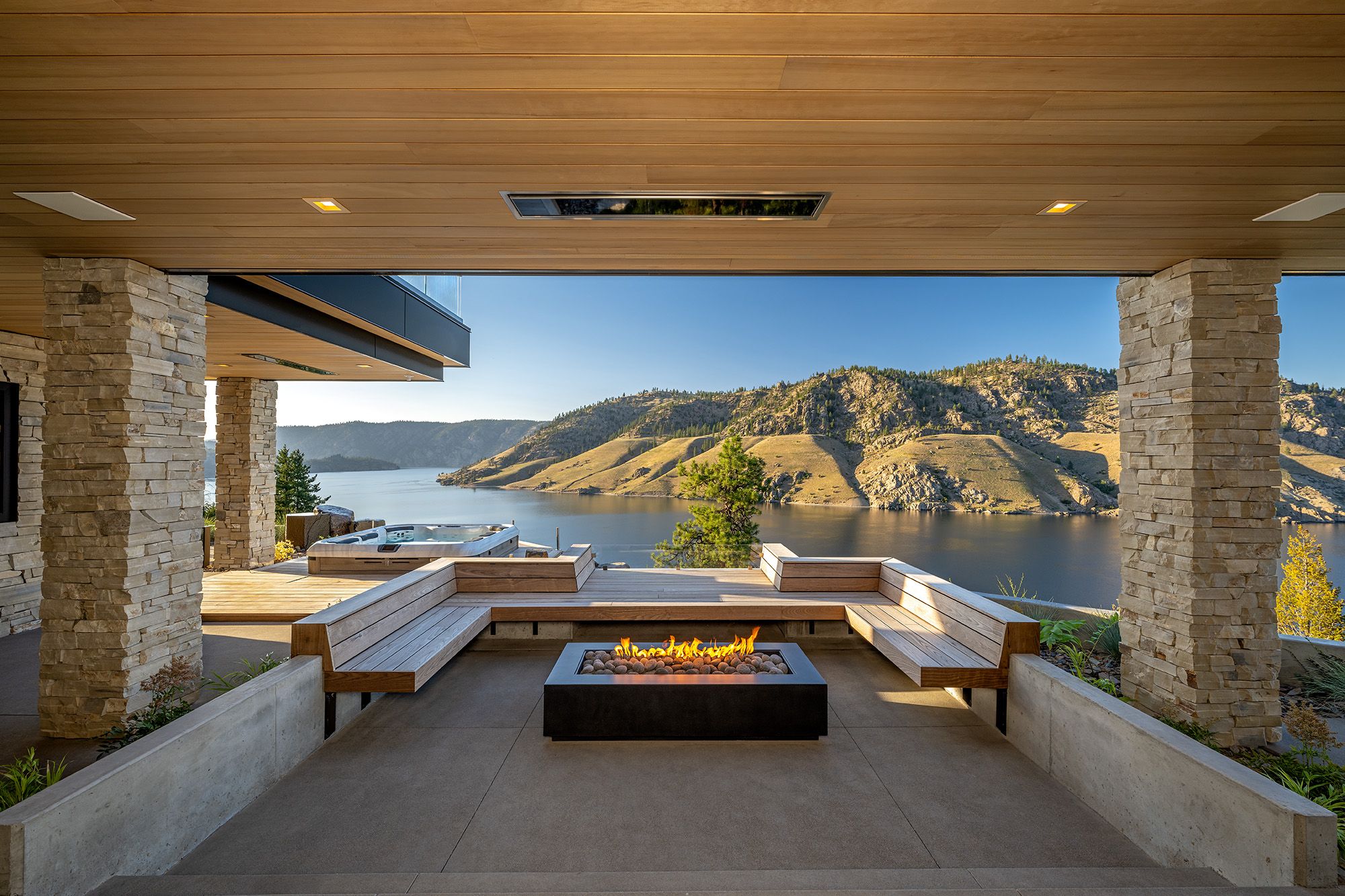 Covered terrace with a fire table above the lake at dusk, Roosevelt